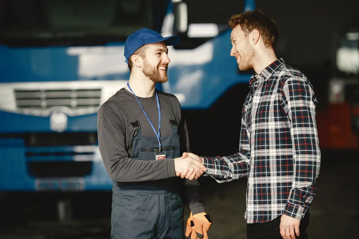Service technician shaking hands with a happy customer in the shop
